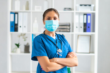 Professional medical doctor working in hospital office, Portrait of young and attractive female physician in protective mask.