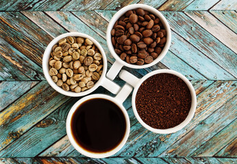 Four coffee stages in white cups: green beans, roasted, ground and brewed. Top view. Specialty coffee culture