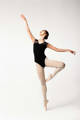 Fototapeta na wymiar Ballerina posing in black body on grey background