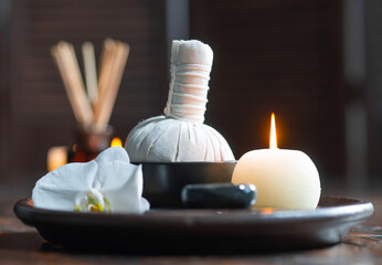 Spa background. Towel, candles, flowers, aroma sticks, massaging stones and herbal balls. Massage, oriental therapy, wellbeing and meditation.