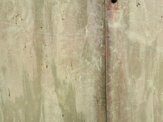 texture of an old metal garage wall exposed to weather and with rust and green paint