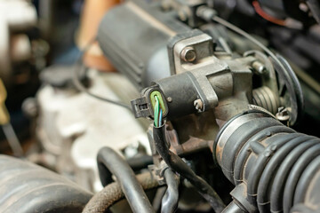 Under the hood of the car, next to the engines, there is an idle speed control valve.