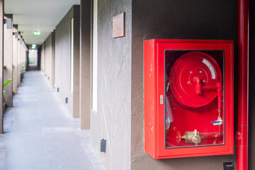 Fire extinguisher and water pump system on the wall background, powerful emergency equipment for...