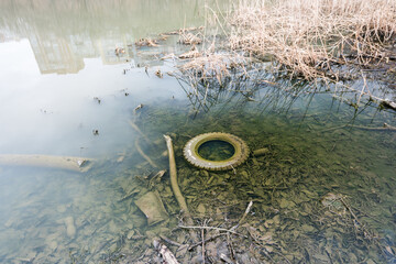Dirty tires lying in water at the bottom of the river.