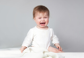 baby crying, age 1 year. studio portrait