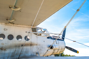 Small old white plane standing in summer field. Personal vintage crop duster closeup