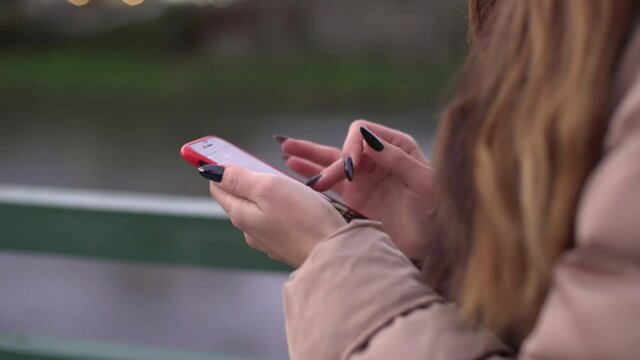 girl communicates on social networks via smartphone on the street. Internet communication.