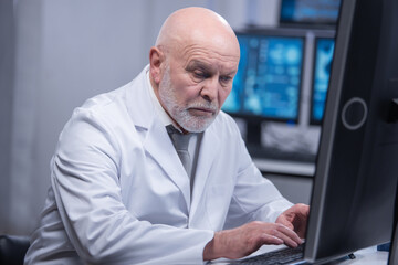 Fototapeta premium Elderly professor is doing a science experiment in a modern laboratory. Genetic engineers workplace. The concept of science, medicine and vaccine development.