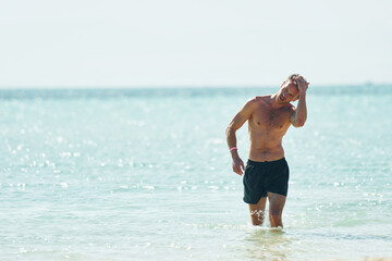 Clear water. Young european man have vacation and enjoying free time on the beach of sea