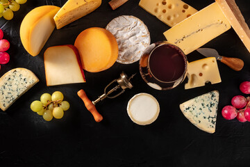 Cheese and wine tasting, shot from above on a dark background