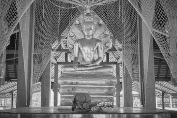 Phayao, Thailand - Dec 20, 2020: Black and White Zoom View Buddha Protected by Serpent or Naga Statue in Jaturamook Sanctuary at Wat Analayo Temple