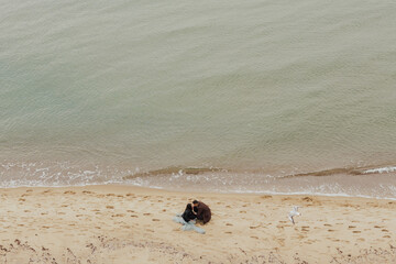 Fototapeta na wymiar Happy lovely couple relax on the beach together. View from above.