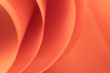 Abstract orange colored macro background, created with curved color paper sheets and macro photographing. Curved lines and shapes and soft vivid color.