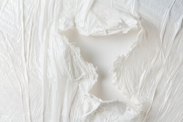 A hole in a crumpled plastic wrap