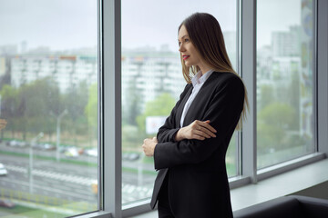 Beautiful business lady standing thoughtfully by the window