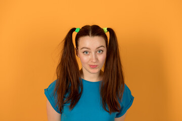 Happy girl with ponytails on a yellow background