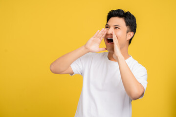 Happy young asian man announces information. He is shouting.