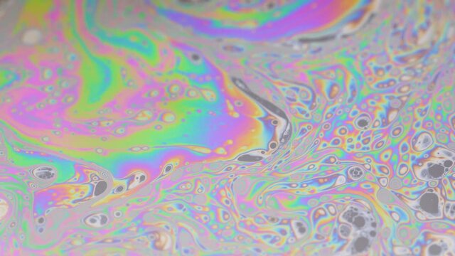 Amazing and crazily moving colorful pattern made by light interference. Macro of the soapy water layer.