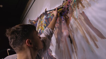 Artist designer draws an eagle on the wall. Craftsman decorator paints picture with acrylic oil...