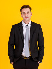 Portrait half body of handsome and executive look french businessman in black suit pose in boss action and positive smile face. Successful and happy business man concept on yellow background