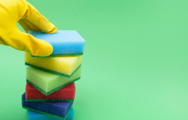 A bunch of colorful kitchen sponges on a green background