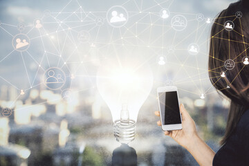 Double exposure of social network sketch hologram and woman holding and using a mobile device.