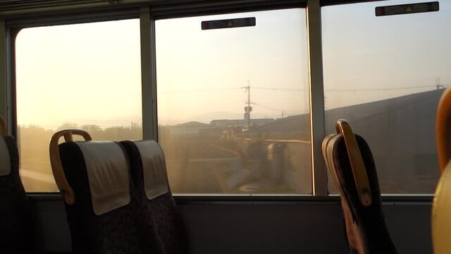 朝陽を浴びる電車の車窓の風景