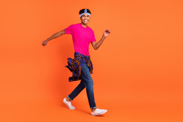 Fototapeta na wymiar Full length photo of charming afro american young man go empty space wear shirt on waist isolated on orange color background