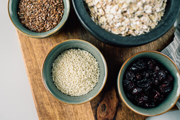 vegetarian set of seeds, sesame, cranberry. composition on a wooden board. Healthy eating, wholesome bowls of cereals 