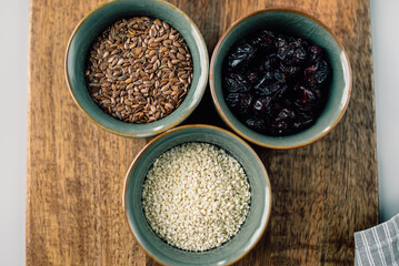 vegetarian set of seeds, sesame, cranberry. composition on a wooden board. Healthy eating, wholesome bowls of cereals 