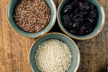 vegetarian set of seeds, sesame, cranberry. composition on a wooden board. Healthy eating, wholesome bowls of cereals 