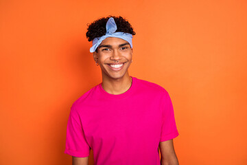 Photo portrait of smiling young guy wearing headband piercing in pink t-shirt isolated on bright orange color background
