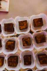 square cake bird's milk sprinkled with cocoa in individual packaging