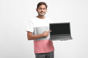 Indian college student showing laptop screen on white background.