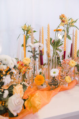 Fototapeta na wymiar yellow and orange fresh flowers on the table in glass vases
