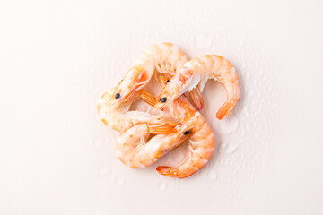 Raw thawed prawns with water drops on a pink background. Mediterranean food. Top view
