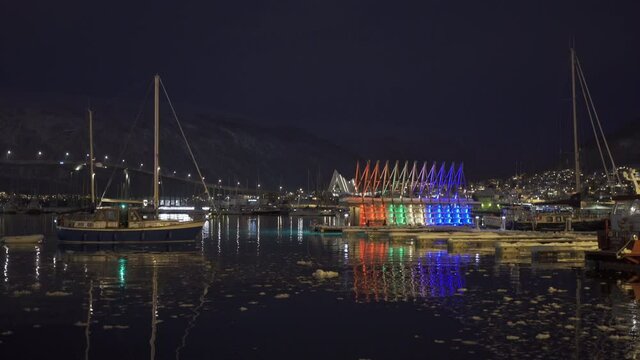 Boat Sailing On Calm River With Floating Sauna In Background In Tromso Harbour At Twilight In Norway. - Static Shot 