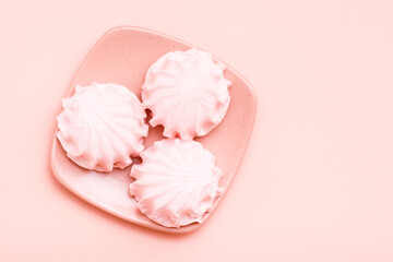 The concept is pink. Pink marshmallows on a saucer on a pink background. Top view