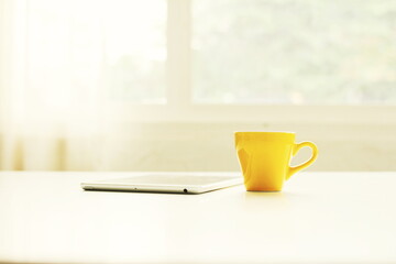 Coffee cup Coffee cup of cappuccino with latte art on wooden and Copy space,Yellow coffee cup,Have a tablet