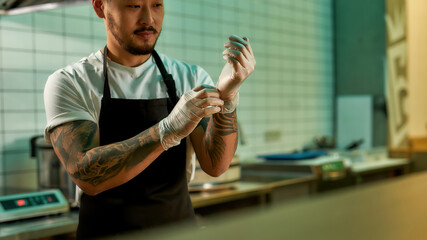 Young man working as a chef in an asian restaurant