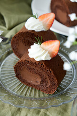 Chocolate Swiss Roll Cake with Chocolate cream filling and Strawberry set on cafe table.