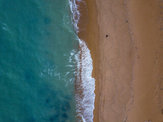 Aerial beach view from above with a walking person in the frame