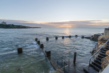 Cloudy sunrise view of Coogee Beach rock pool, Sydney, Australia.