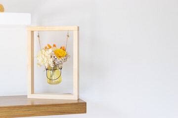 Dried flowers in glass container inside a frame