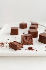 Chocolate candies with ganash on the white plate