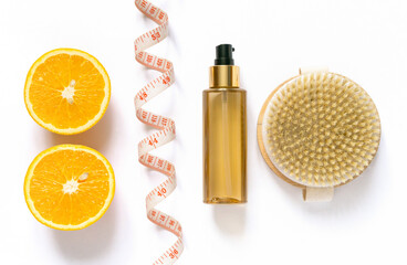 Anti-cellulite care products. Brush for dry massage and oil on white background, top view