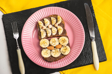 Toasted whole wheat bread with chocolate nuts paste nutella topping, banana, chia seeds, almonds and hazelnuts toast. Healthy proper nutrition for breakfast