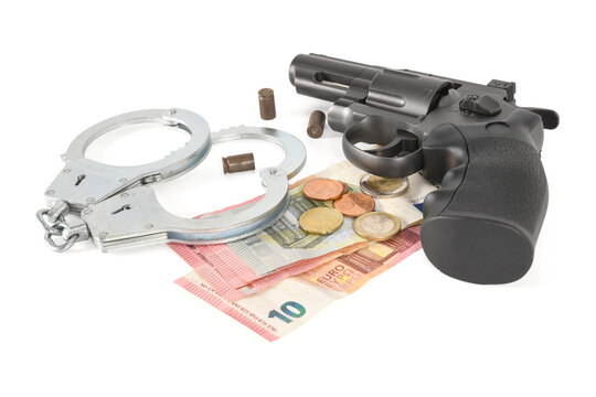 Gun, used cartridge cases, police handcuffs and bundle of euro money. Concept of crime and inevitability of punishment. Isolated on white background, high resolution closeup.