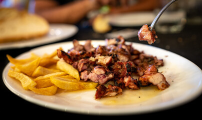 Sweetbread with french fries and fork taking slice