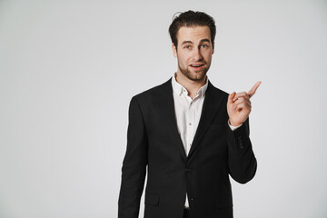 Unshaven brunette man in jacket pointing finger aside